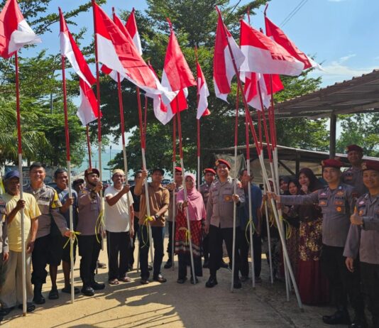 DITRESKRIMSUS POLDA KEPRI BAGIKAN DAN PASANG BENDERA MERAH PUTIH BERSAMA MASYARAKAT
